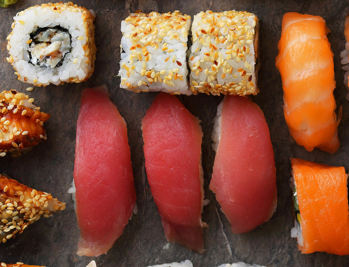 various pieces of sushi on a grey stone slab